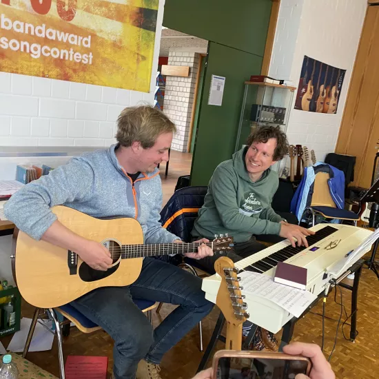 Zwei musizierende Männer mit Gitarre und Keyboard