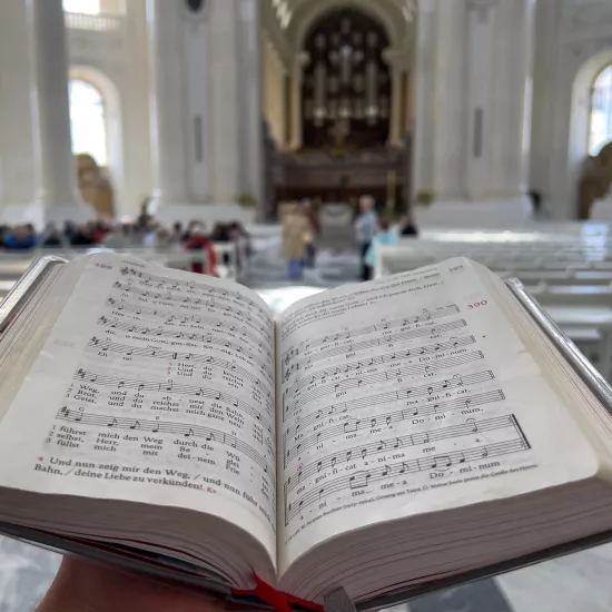 Ein aufgeschlagenes Gesangbuch in einer großen Kirche